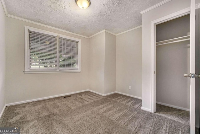 unfurnished bedroom featuring dark colored carpet, crown molding, a textured ceiling, and a closet