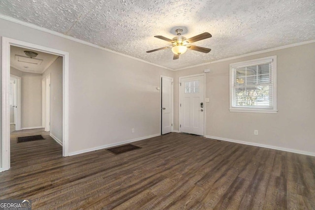 empty room with a textured ceiling, dark hardwood / wood-style flooring, ceiling fan, and crown molding