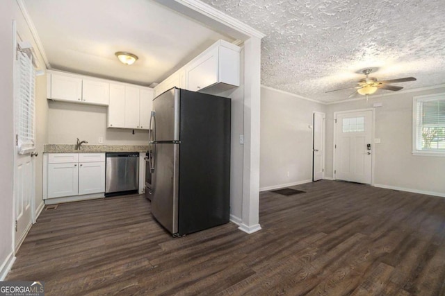 kitchen with appliances with stainless steel finishes, dark hardwood / wood-style flooring, ceiling fan, crown molding, and white cabinetry