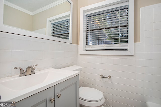 bathroom featuring vanity, ornamental molding, tile walls, and toilet