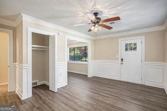 foyer with dark hardwood / wood-style floors, ceiling fan, ornamental molding, and a textured ceiling