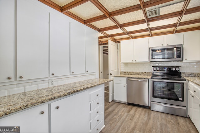 kitchen with light stone countertops, backsplash, stainless steel appliances, light hardwood / wood-style flooring, and white cabinets