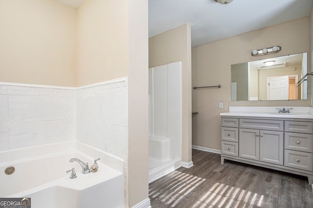 bathroom featuring a tub, vanity, and wood-type flooring