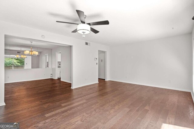 unfurnished living room with dark hardwood / wood-style flooring and ceiling fan with notable chandelier