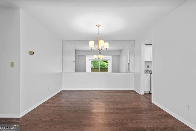 unfurnished dining area with dark hardwood / wood-style floors and an inviting chandelier