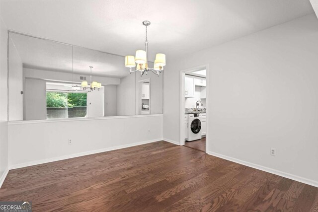 interior space with sink, washer / dryer, dark wood-type flooring, and an inviting chandelier