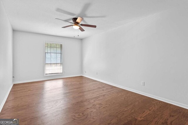 unfurnished room with dark hardwood / wood-style flooring and ceiling fan