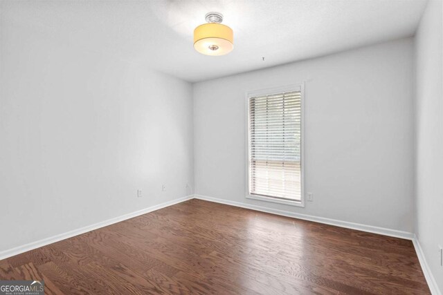 empty room with dark hardwood / wood-style flooring