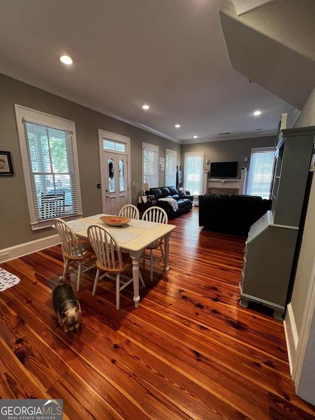 dining area with crown molding and dark hardwood / wood-style flooring