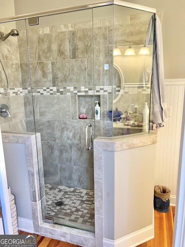 bathroom with hardwood / wood-style floors and a shower with door