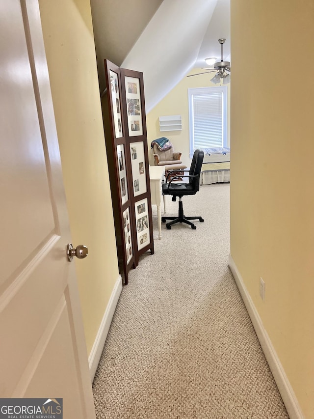 home office featuring carpet flooring, ceiling fan, and vaulted ceiling