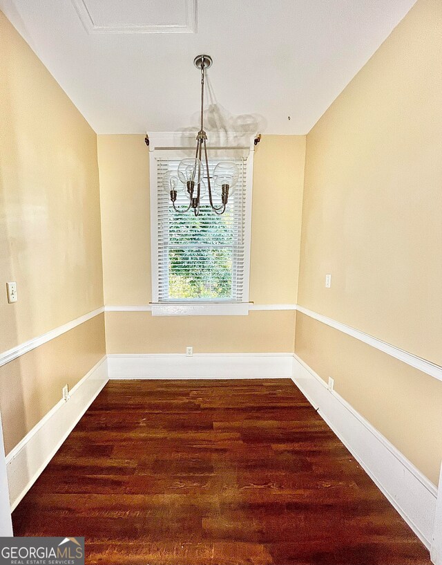 unfurnished dining area with hardwood / wood-style flooring and a notable chandelier