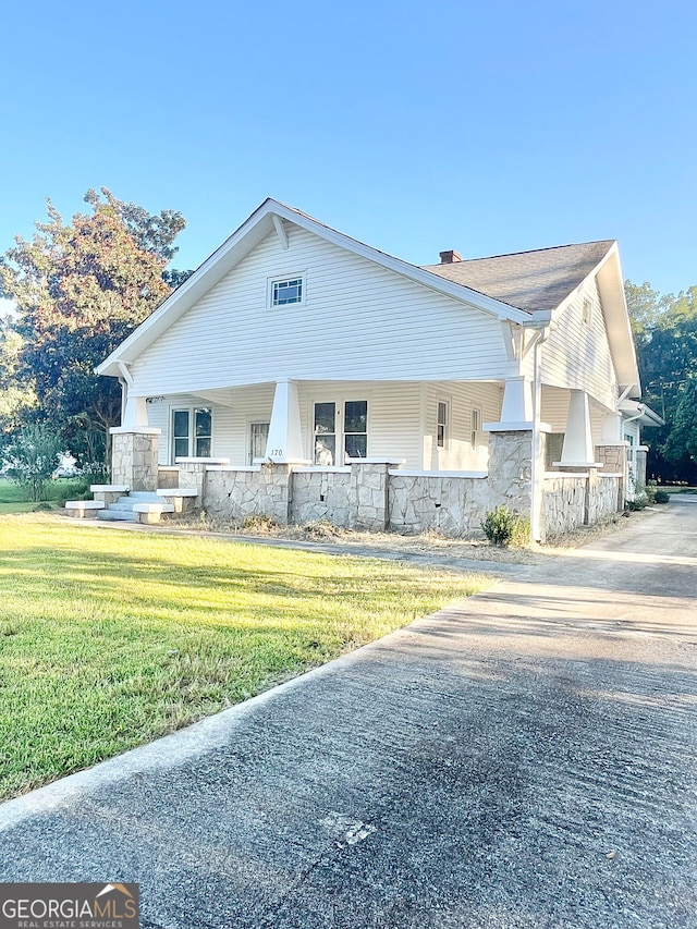 view of front of property with covered porch and a front lawn