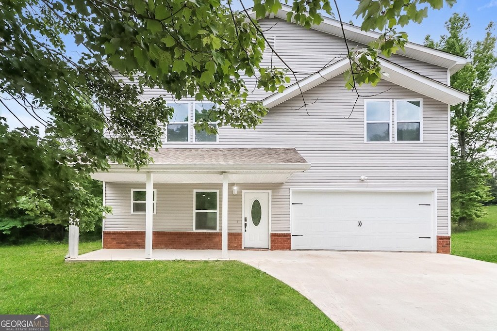 view of property featuring a front yard and a garage