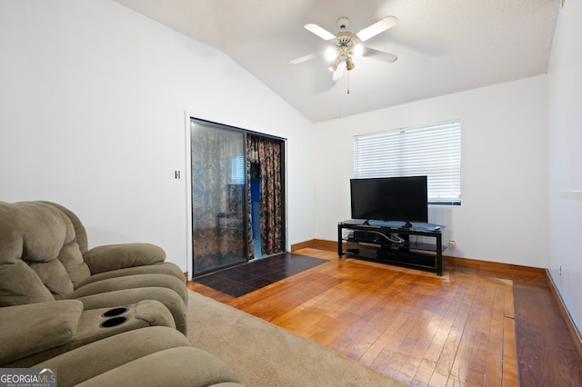 living room with ceiling fan, lofted ceiling, and wood-type flooring