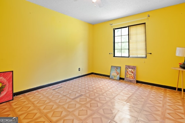 spare room featuring ceiling fan and a textured ceiling