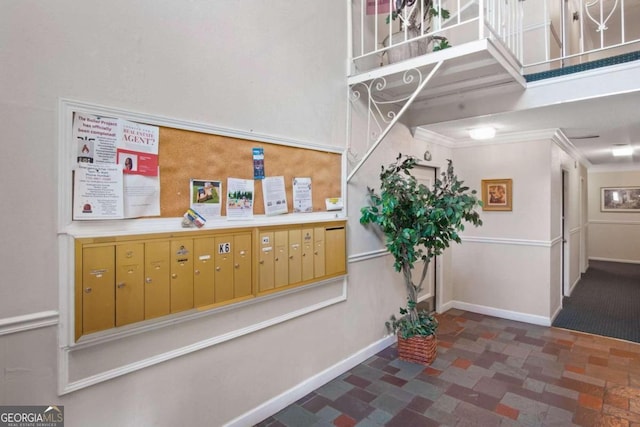 interior space with a mail area, dark tile flooring, and crown molding