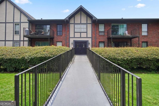 view of front of house featuring a front yard and a balcony