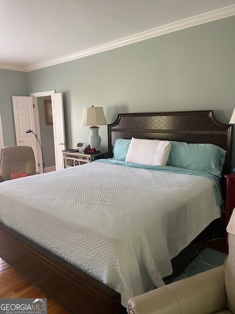 bedroom featuring hardwood / wood-style flooring and ornamental molding