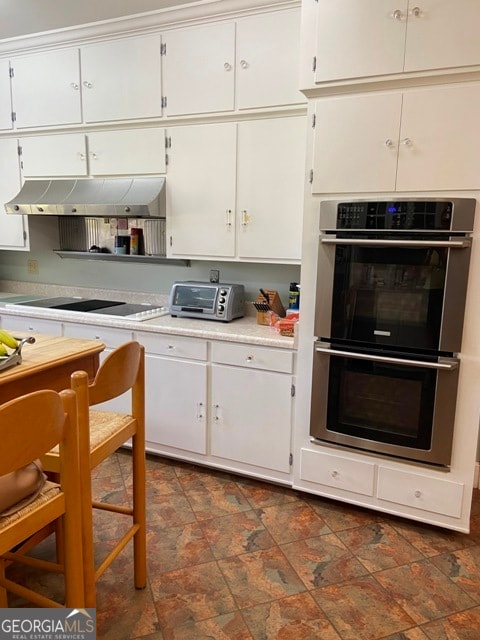 kitchen featuring white cabinets, stovetop, and double oven