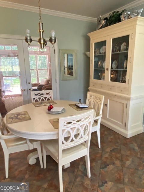 dining space featuring french doors, a notable chandelier, and ornamental molding