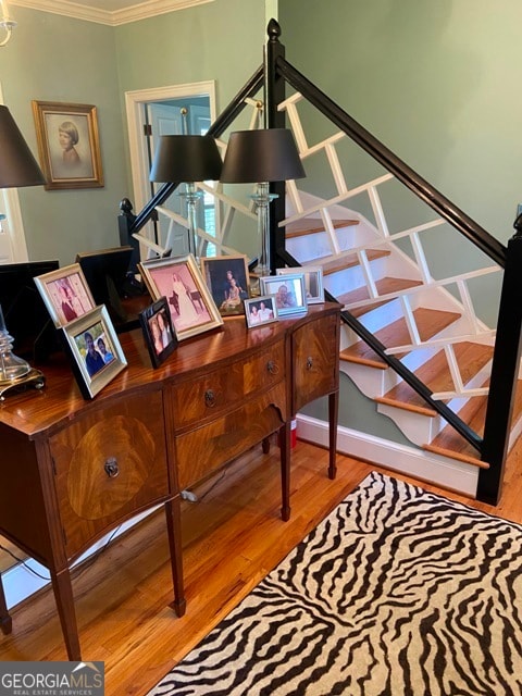 home office with wood-type flooring and ornamental molding