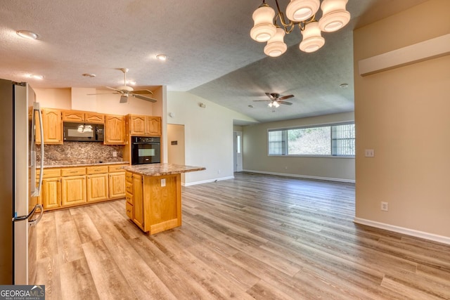 kitchen featuring a center island, light hardwood / wood-style floors, vaulted ceiling, and black appliances