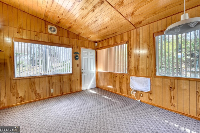 unfurnished room featuring carpet, wooden walls, and wooden ceiling