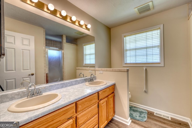 bathroom featuring dual bowl vanity, hardwood / wood-style floors, and toilet