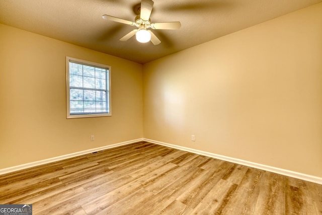 empty room with hardwood / wood-style floors and ceiling fan