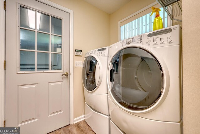 washroom with light hardwood / wood-style floors and washing machine and clothes dryer