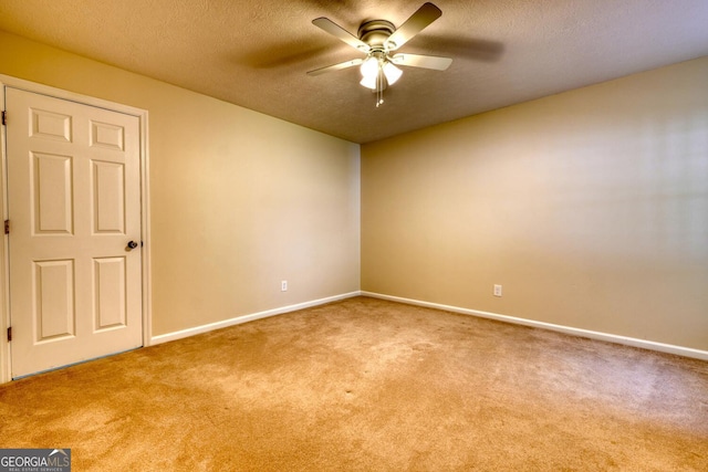 carpeted spare room featuring ceiling fan and a textured ceiling