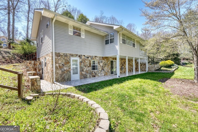 rear view of house with a lawn and a patio area