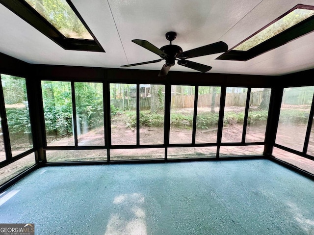 unfurnished sunroom featuring ceiling fan and a healthy amount of sunlight