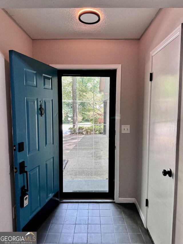 tiled entrance foyer with a textured ceiling