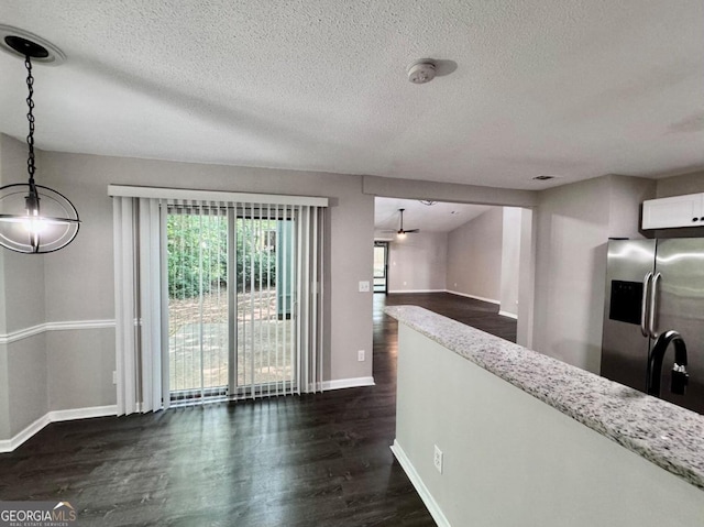 kitchen with dark wood-type flooring, white cabinetry, hanging light fixtures, stainless steel fridge with ice dispenser, and ceiling fan