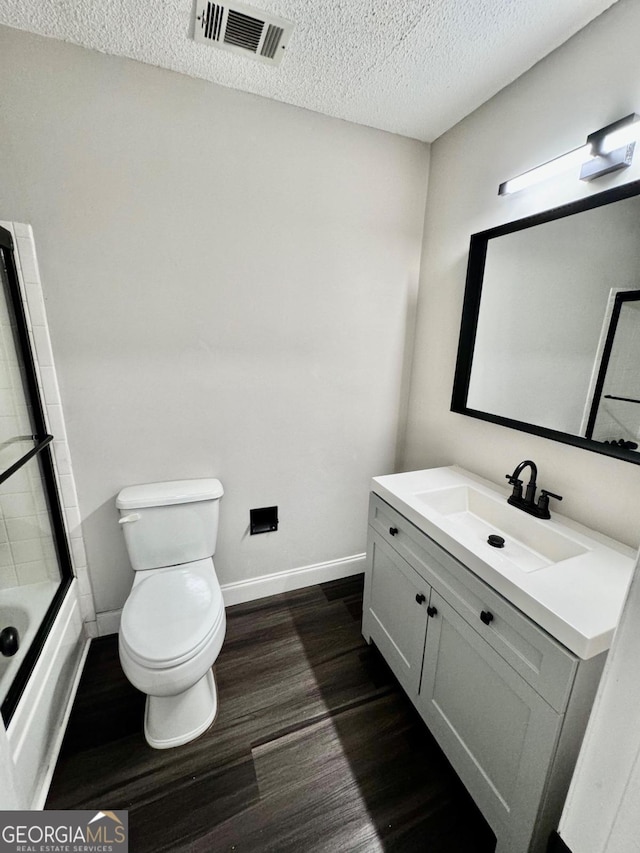 full bathroom with toilet, vanity, hardwood / wood-style flooring, shower / bathtub combination, and a textured ceiling