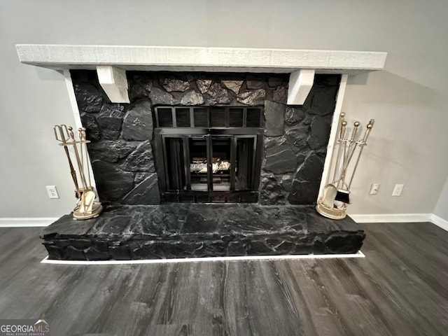 room details with hardwood / wood-style flooring and a stone fireplace