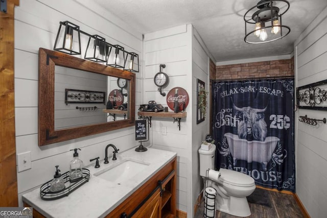 bathroom featuring hardwood / wood-style floors, vanity, toilet, and a textured ceiling