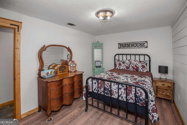 bedroom featuring hardwood / wood-style floors and a textured ceiling