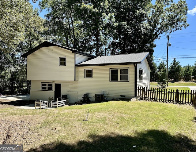 rear view of house featuring a yard and central air condition unit