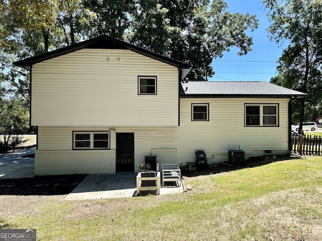 rear view of property featuring a lawn, a patio, and central AC