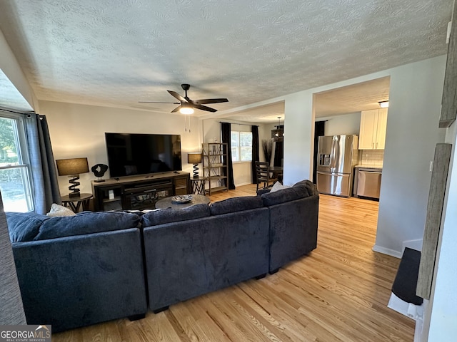 living room with a healthy amount of sunlight, ceiling fan, and light hardwood / wood-style floors