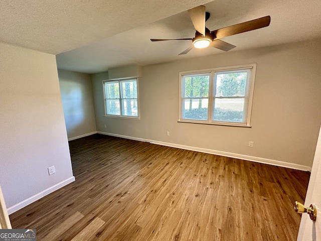 spare room with a textured ceiling, ceiling fan, and hardwood / wood-style floors