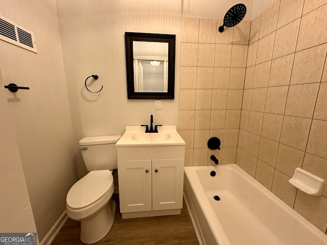 full bathroom with vanity, toilet, hardwood / wood-style floors, and tiled shower / bath