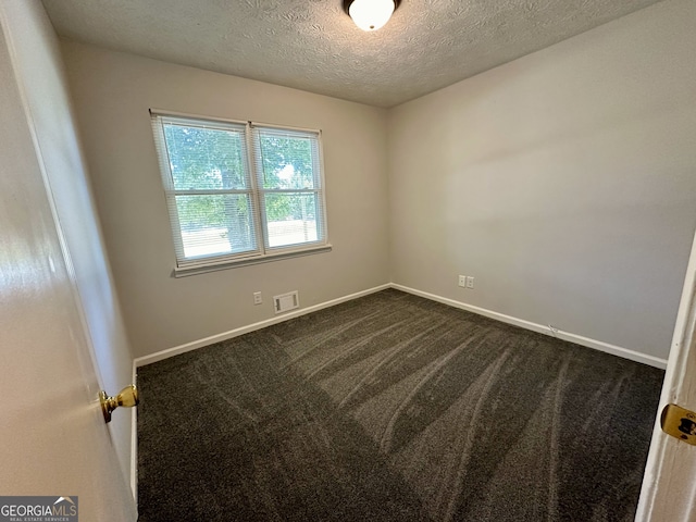 spare room with a textured ceiling and carpet flooring