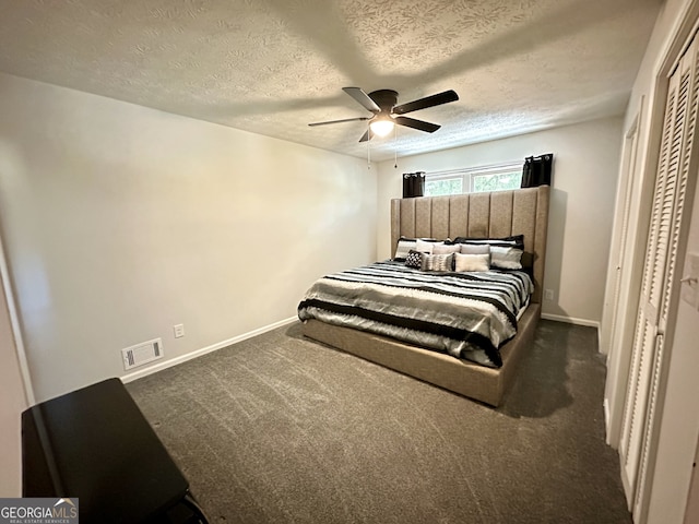 carpeted bedroom featuring a textured ceiling and ceiling fan