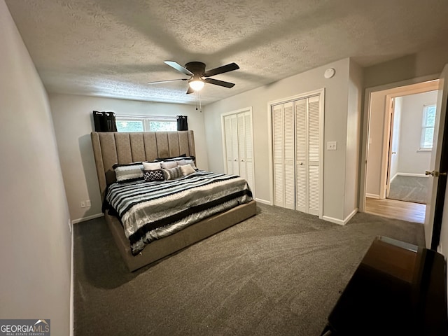 bedroom featuring ceiling fan, carpet, multiple closets, and a textured ceiling