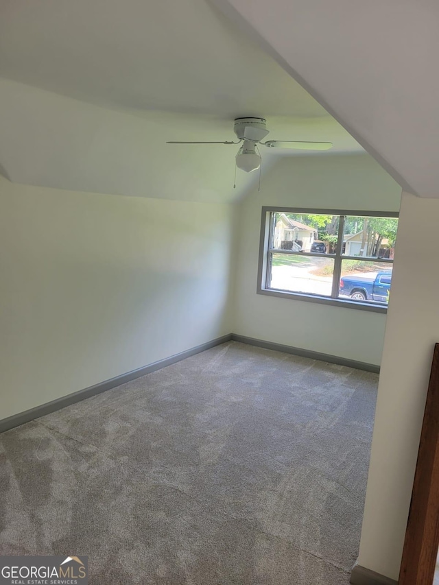 carpeted empty room with ceiling fan and lofted ceiling