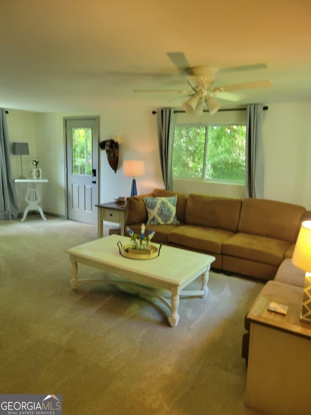 living room with ceiling fan, plenty of natural light, and light colored carpet